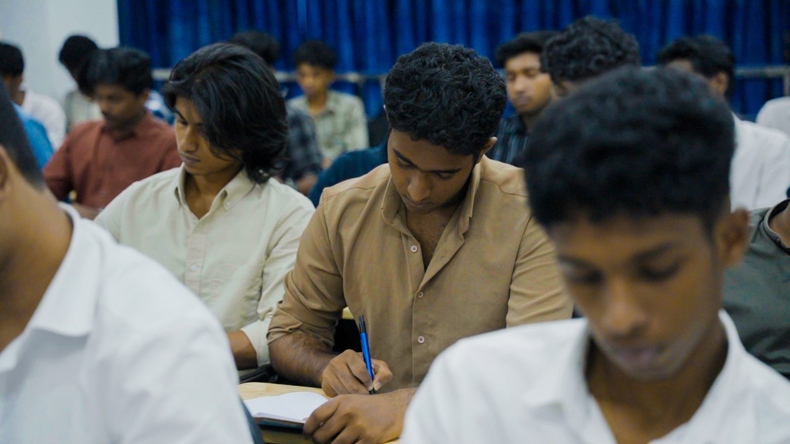 NavPath students writing at their desks, heads down over their papers