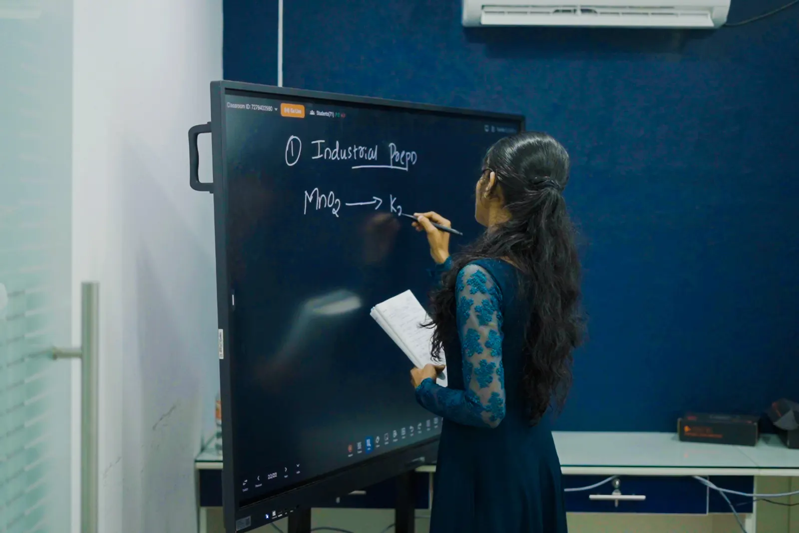 A NavPath faculty member working through a chemistry problem on the classroom smartboard