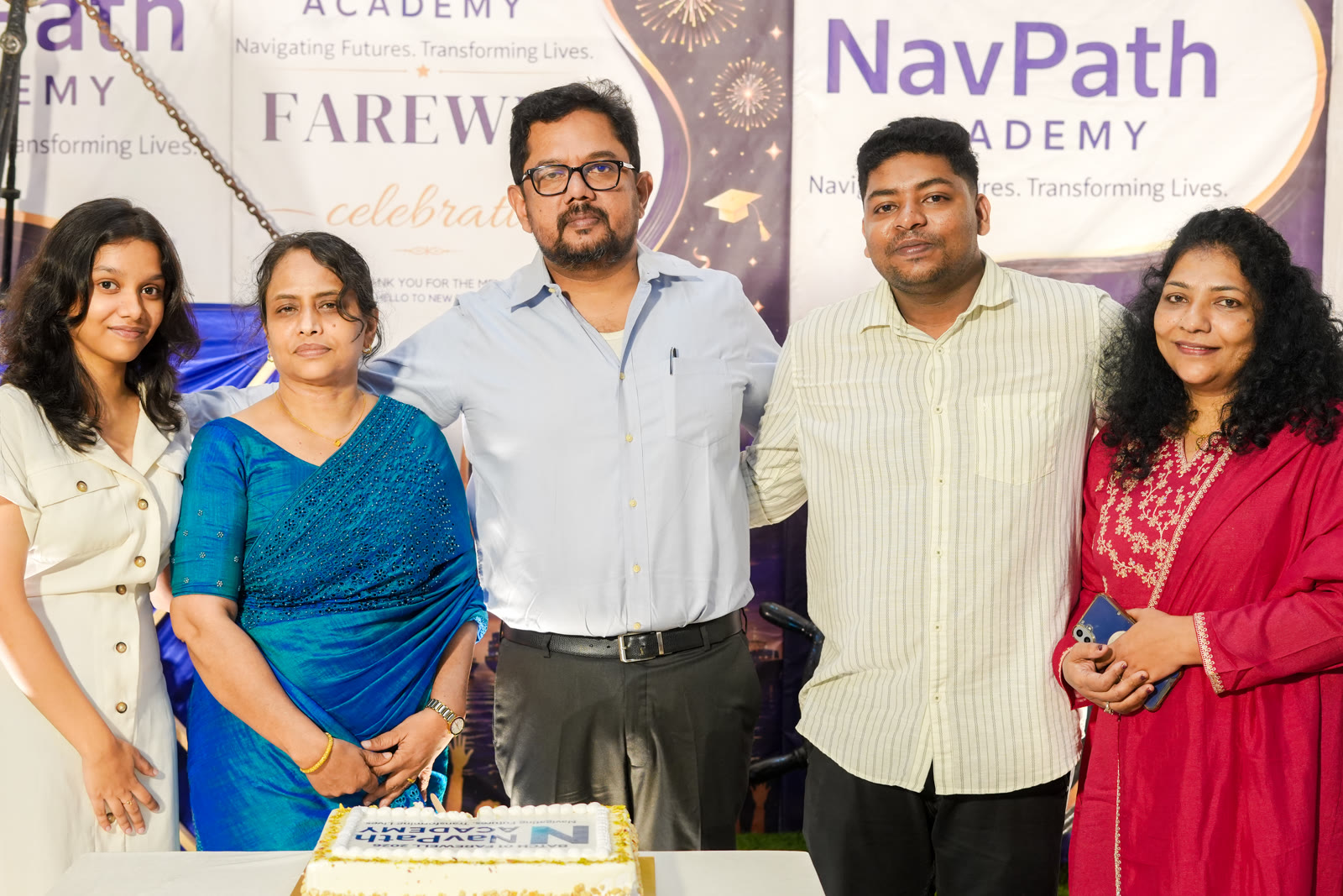 Mentors and students cutting a cake at a batch farewell