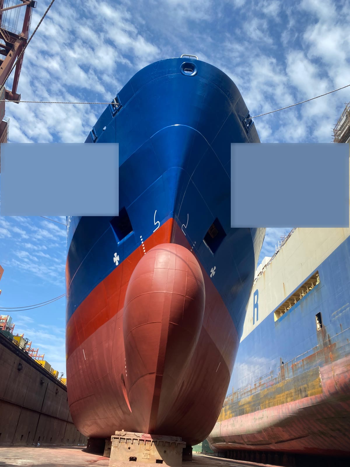 The bow of a merchant ship in dry dock, seen from below