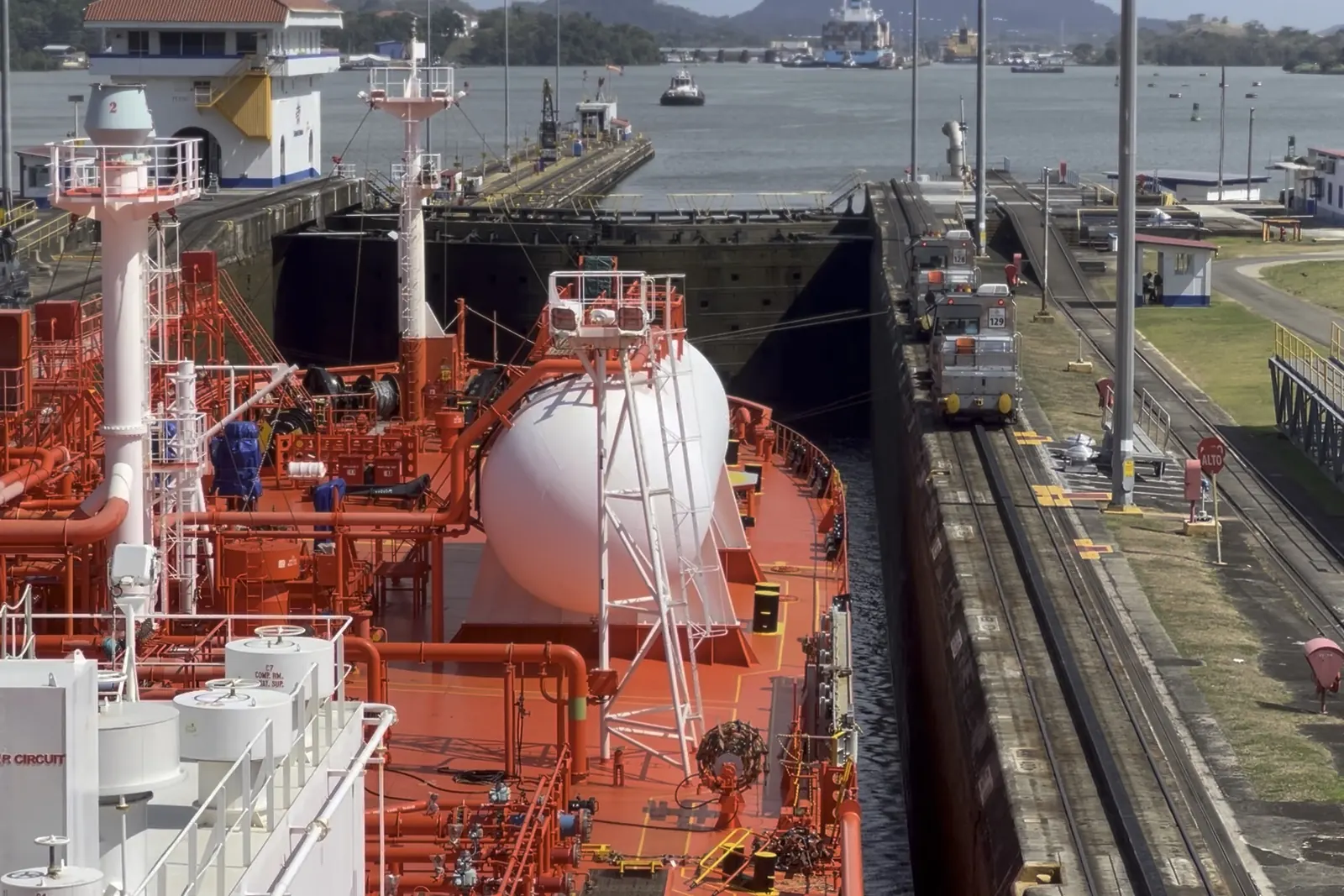Crew at work on a gas carrier's foredeck inside a canal lock