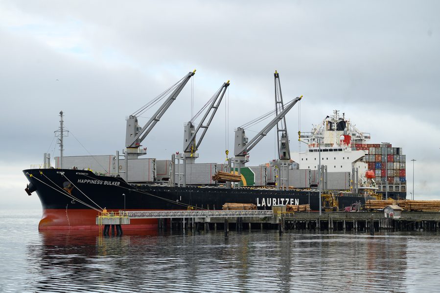 A bulk carrier alongside with its cranes working cargo