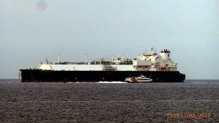 An LNG carrier under way, its containment tanks visible on deck
